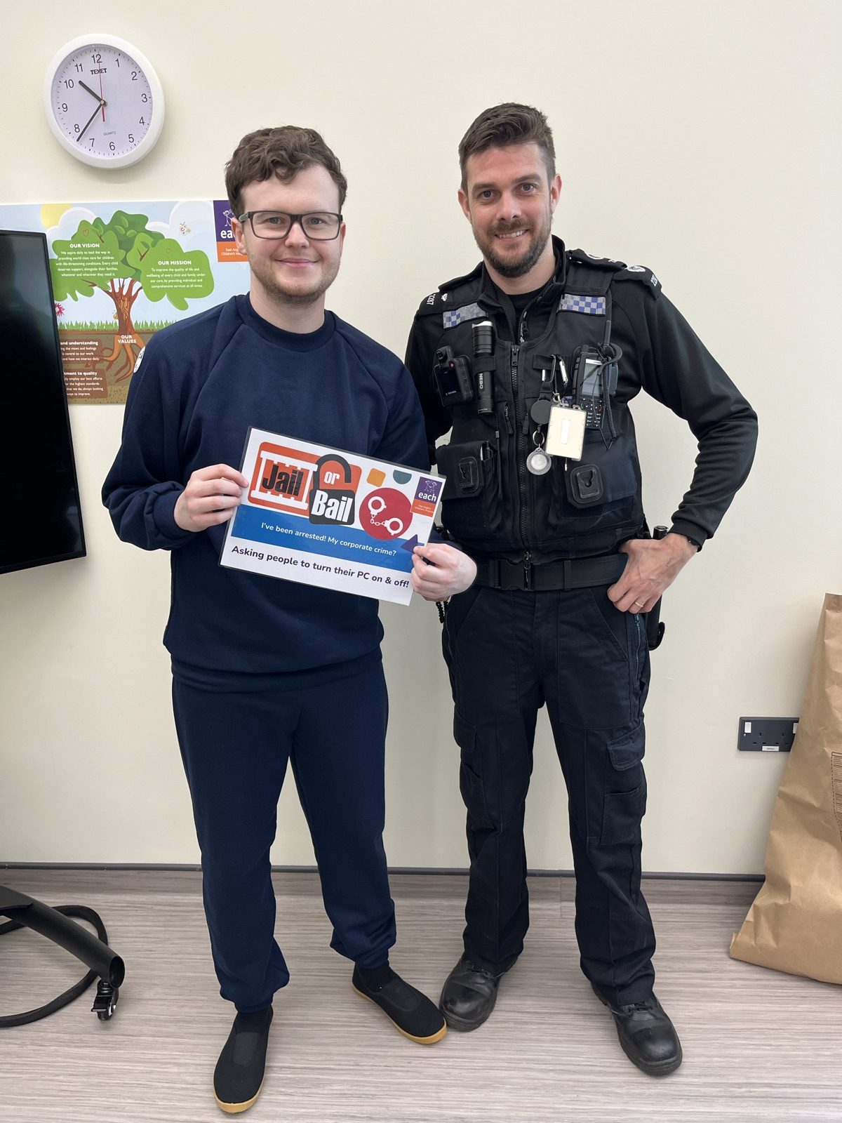 Alex Harvey in prison overalls holding his Jail or Bail charge sign next to a police officer at The Nook